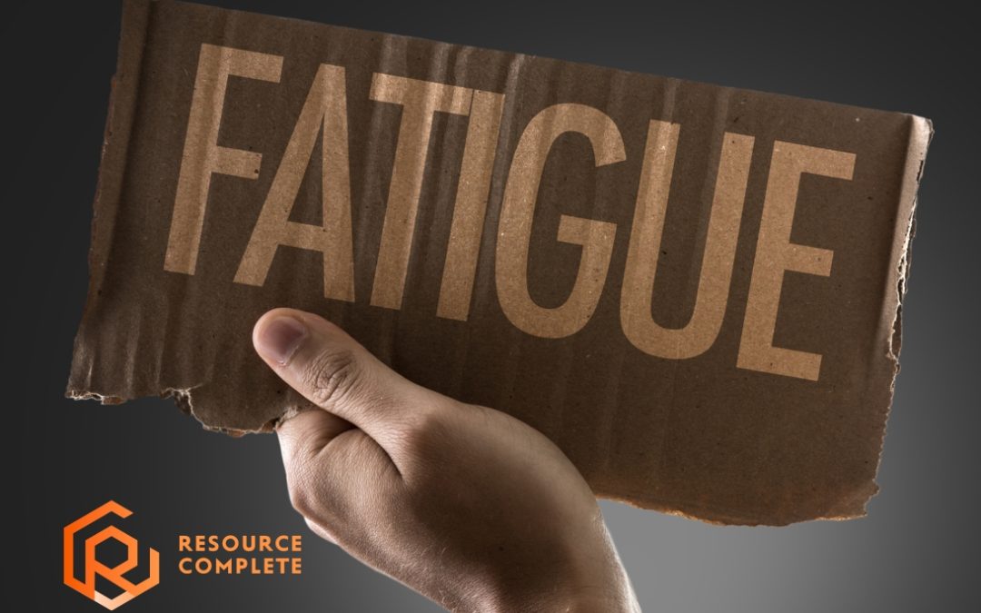 Hand holding a cardboard sign reading “FATIGUE,” Resource Complete logo in corner.